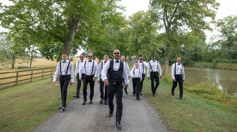 Groomsmen walking through the grounds at The Barns at Alswick