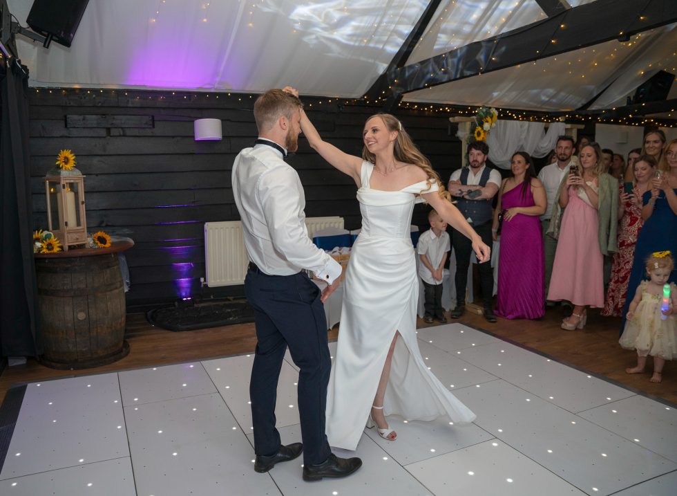 Molly and Tommy share a joyful moment on the dance floor as Molly twirls in her wedding gown, choreographing their first dance at The White Horse Southill.