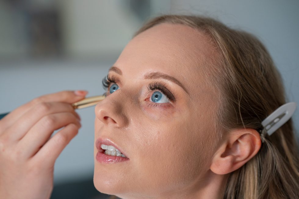 Close-up photo of the bride getting her wedding makeup applied, focusing on the detail and the light on her eyes during the bridal prep session. Candid beauty photography by a Bedfordshire wedding photographer.