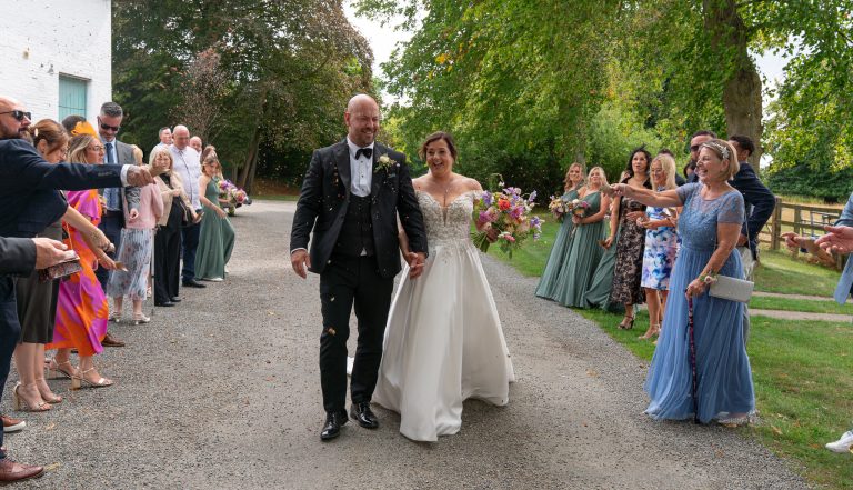 Couple walking through their guests at The Barns at Alswick