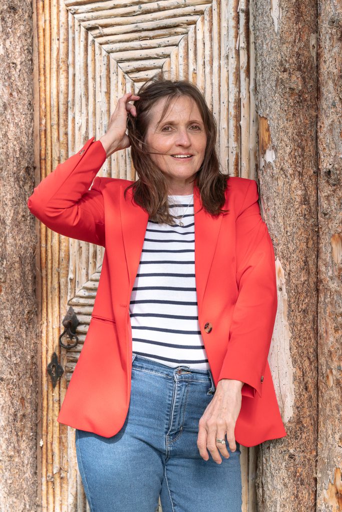 Tracy, relaxed documentary wedding photographer in Hitchin, Hertfordshire, in a red blazer