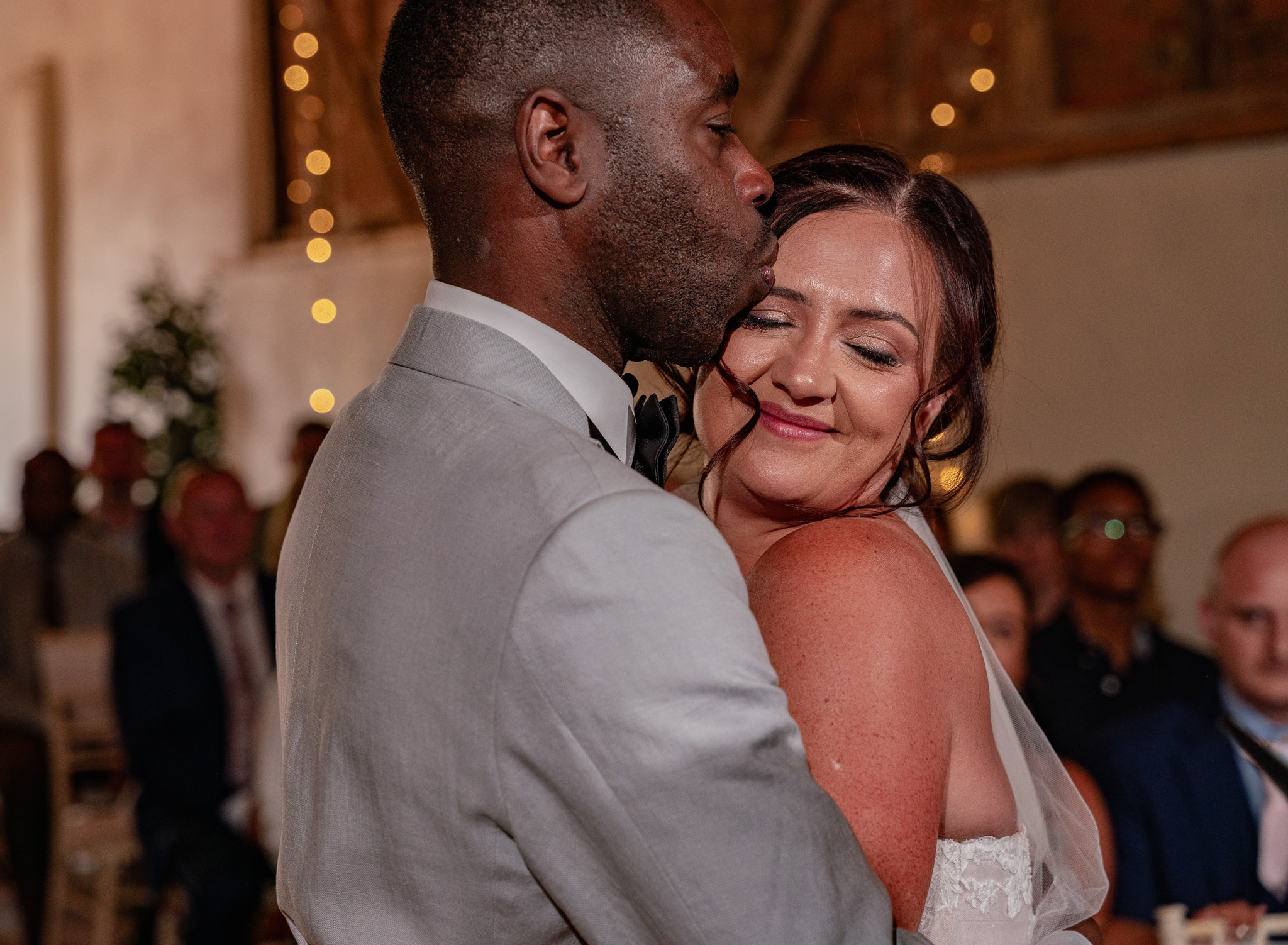 Newlywed couple sharing an emotional embrace moments after being announced husband and wife at their barn wedding in Hertfordshire