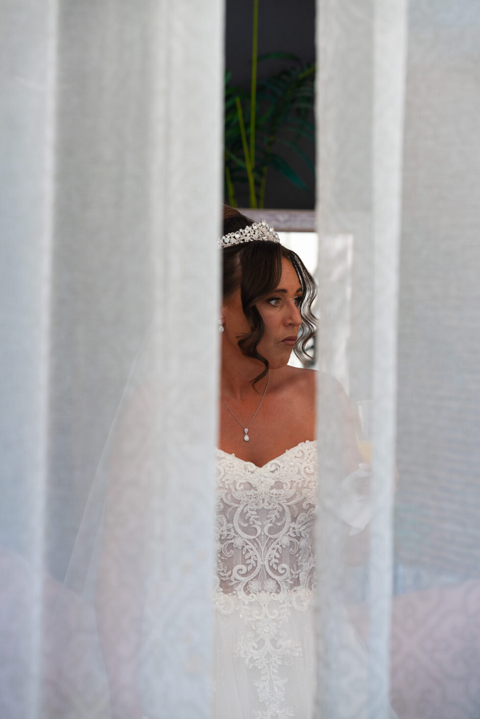 Bride glimpsed through a gap in the curtains while getting ready