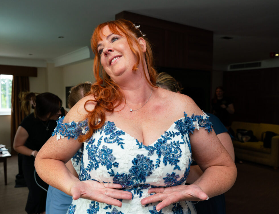 Smiling woman in a floral dress laughing while getting ready for a wedding