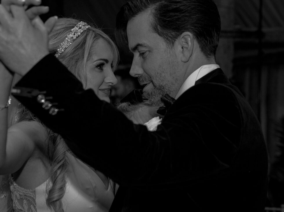 Black and white close-up of the bride in a sparkly tiara and her groom, eyes locked, during their first dance at South Farm