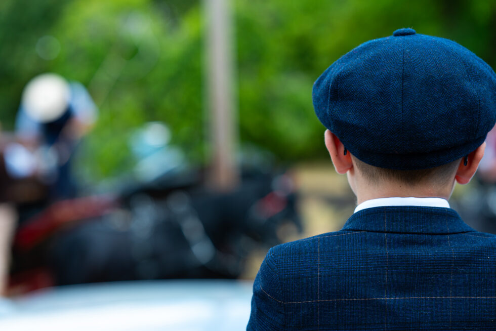 Child in a flat cap seen from behind, out of focus background
