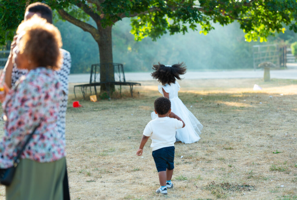 Child running across a park with a woman watching in the distance